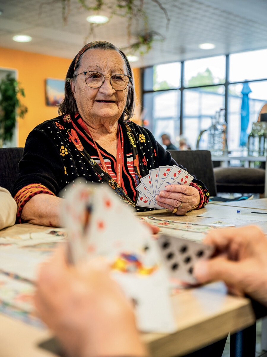Une personne âgée jouant aux cartes