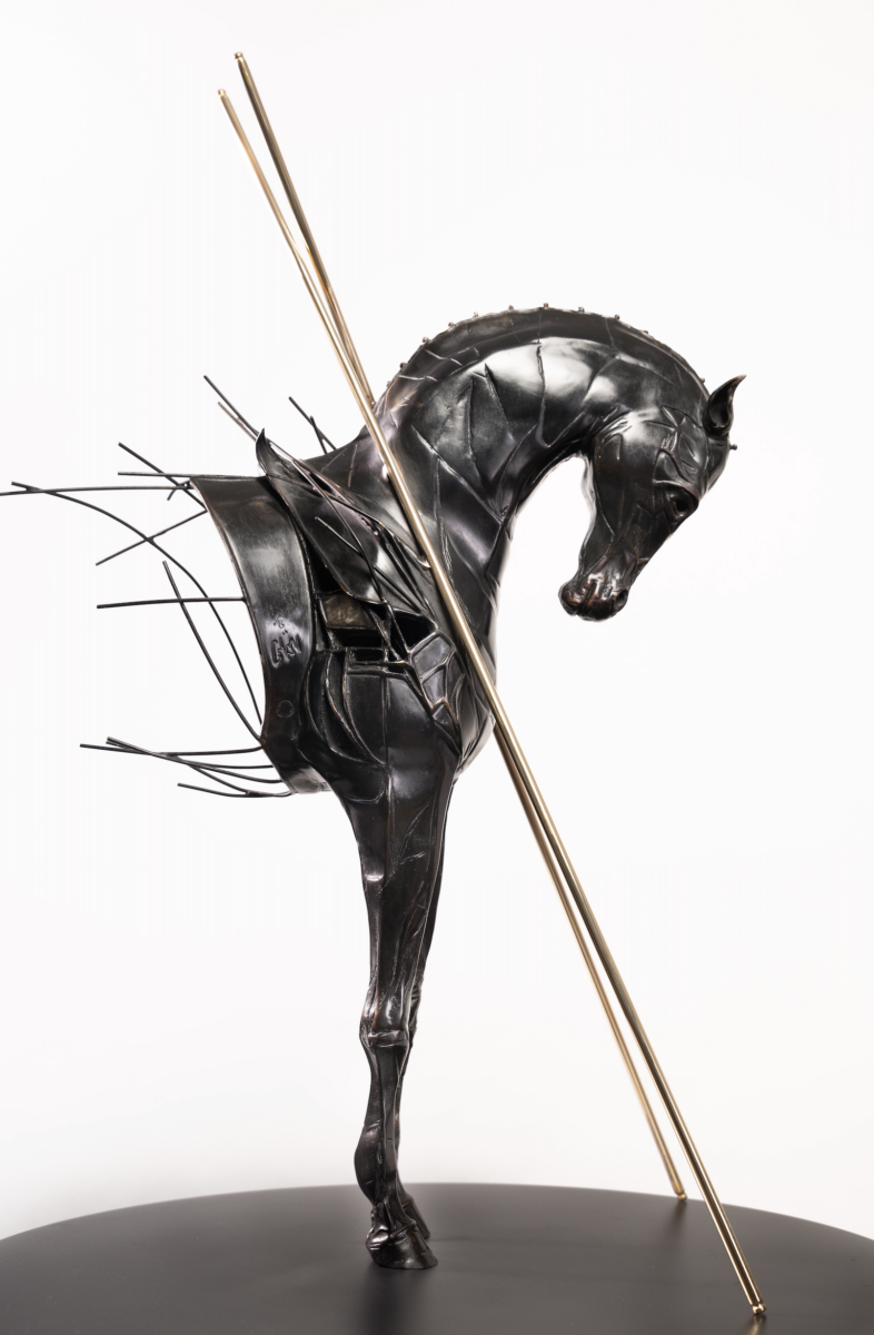 Une sculpture moderne et abstraite de chevaux en métal sombre, partiellement fragmentée par des tiges et des espaces ouverts, présente deux poteaux dorés se croisant en diagonale - une pièce maîtresse saisissante inspirée par Les nocturnes du Château de Talmont. - Édition Offset 5 (Partenaire de votre communication locale en Vendée)