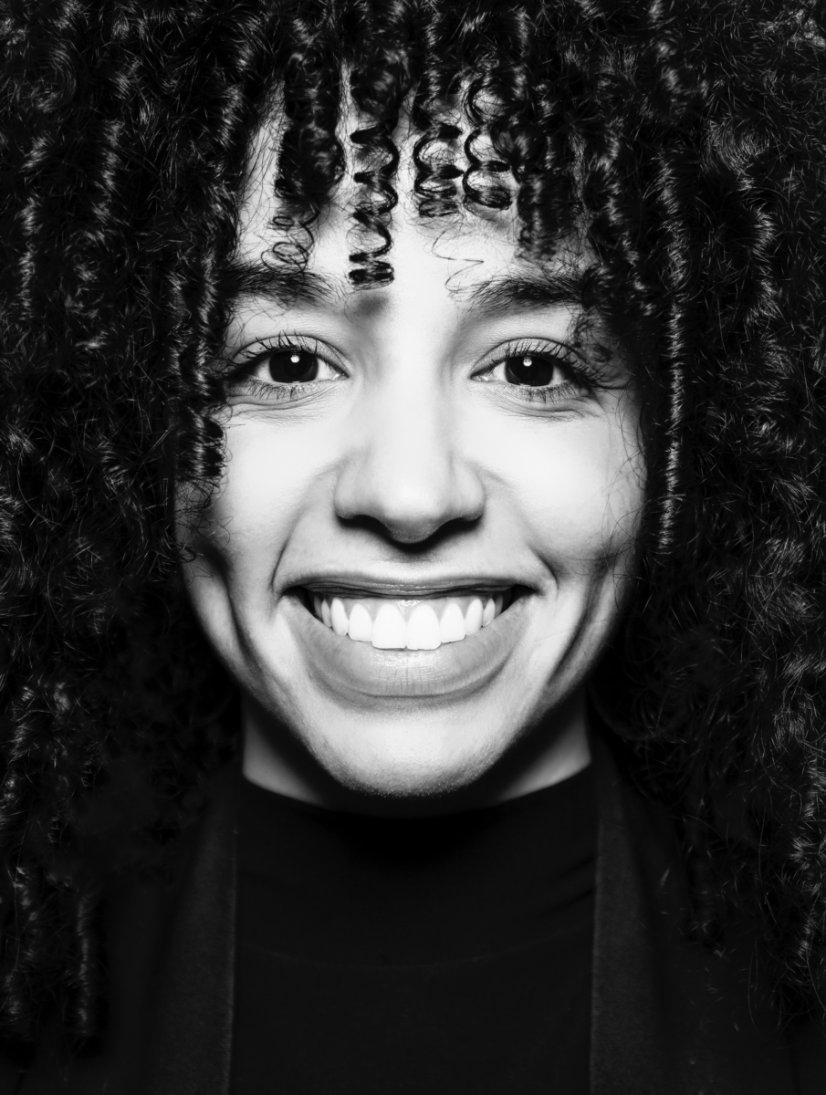 Portrait noir et blanc en gros plan de Simon Boisliveau, une personne souriante aux cheveux bouclés, montrant ses fossettes et ses dents, regardant directement l'appareil photo. - Édition Offset 5 (Partenaire de votre communication locale en Vendée)