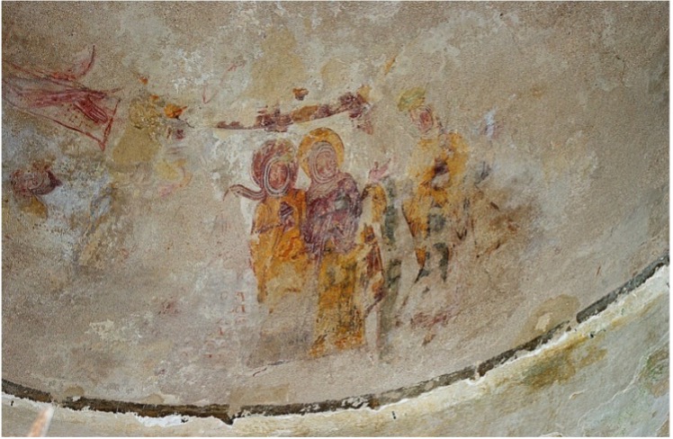 Fresque ancienne défraîchie sur un mur de pierre incurvé à La Roche sur Yon, représentant plusieurs figures humaines auréolées, vêtues de longues robes, semblant faire partie d'une scène religieuse ou historique. Les couleurs sont atténuées et certaines parties de la peinture sont usées. - Édition Offset 5 (Partenaire de votre communication locale en Vendée)