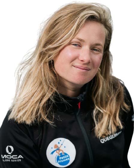 Une femme aux longs cheveux blonds, portant une veste noire avec les logos des sponsors Petits Princes, MOCA GLOBE SERIES, et 2 Mains 4 Cornes, sourit légèrement sur un fond blanc. - Édition Offset 5 (Partenaire de votre communication locale en Vendée)