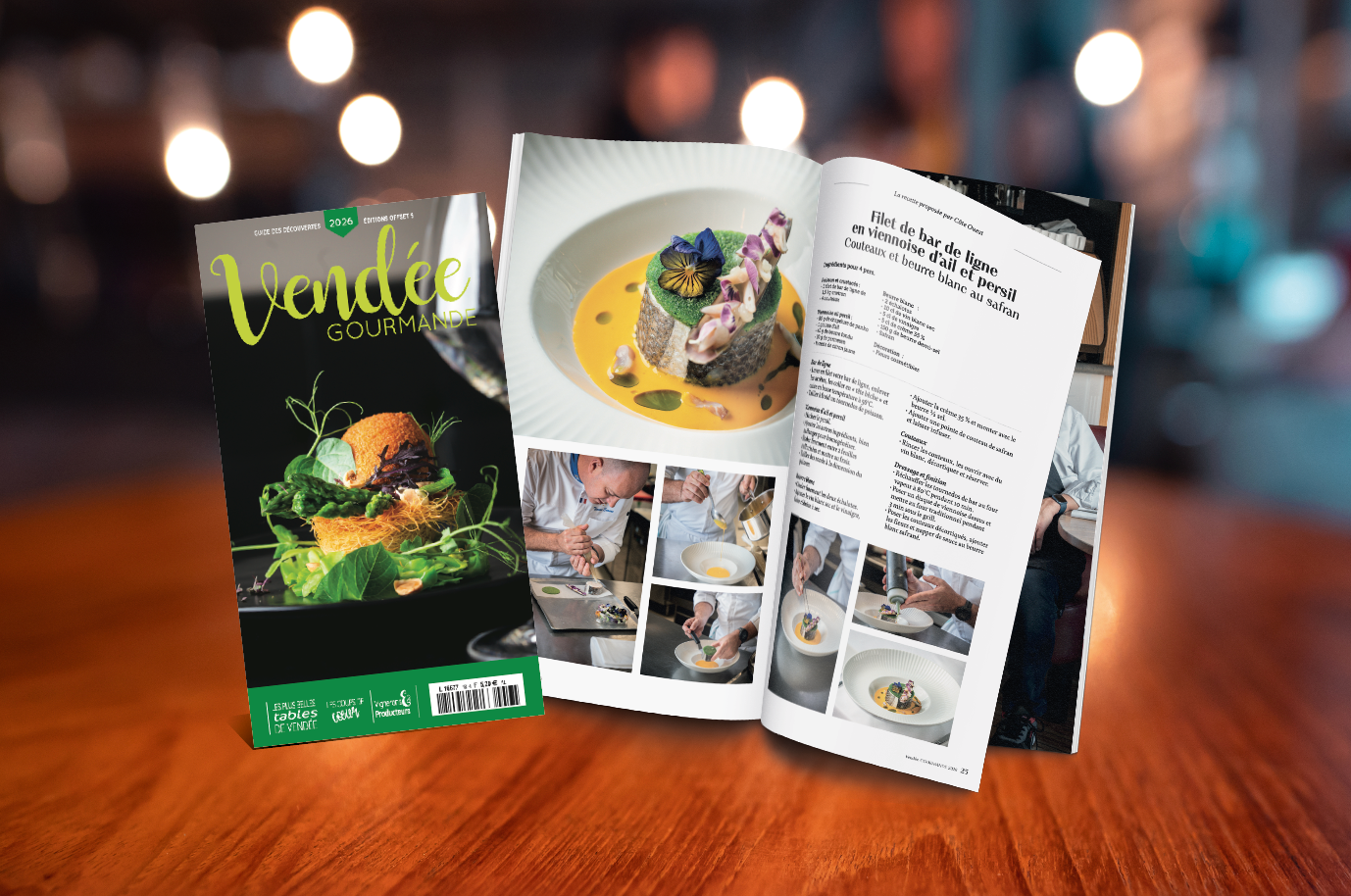 Un magazine intitulé Vendée Gourmande 2025 est posé sur une table en bois à côté d'un numéro ouvert présentant des plats gastronomiques, des recettes et des chefs au travail, sur fond de restaurant flou. - Édition Offset 5 (Partenaire de votre communication locale en Vendée)